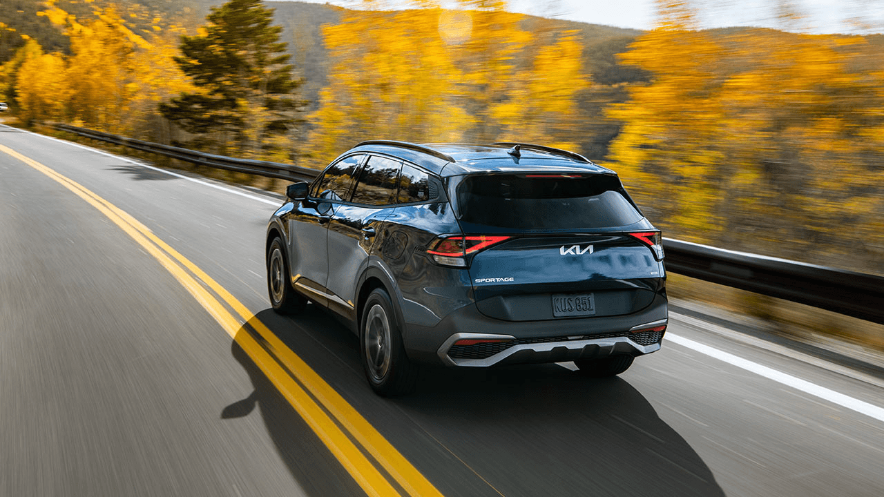 Vue 3/4 arrière du Kia Sportage HEV/PHEV 2025 sur la route.