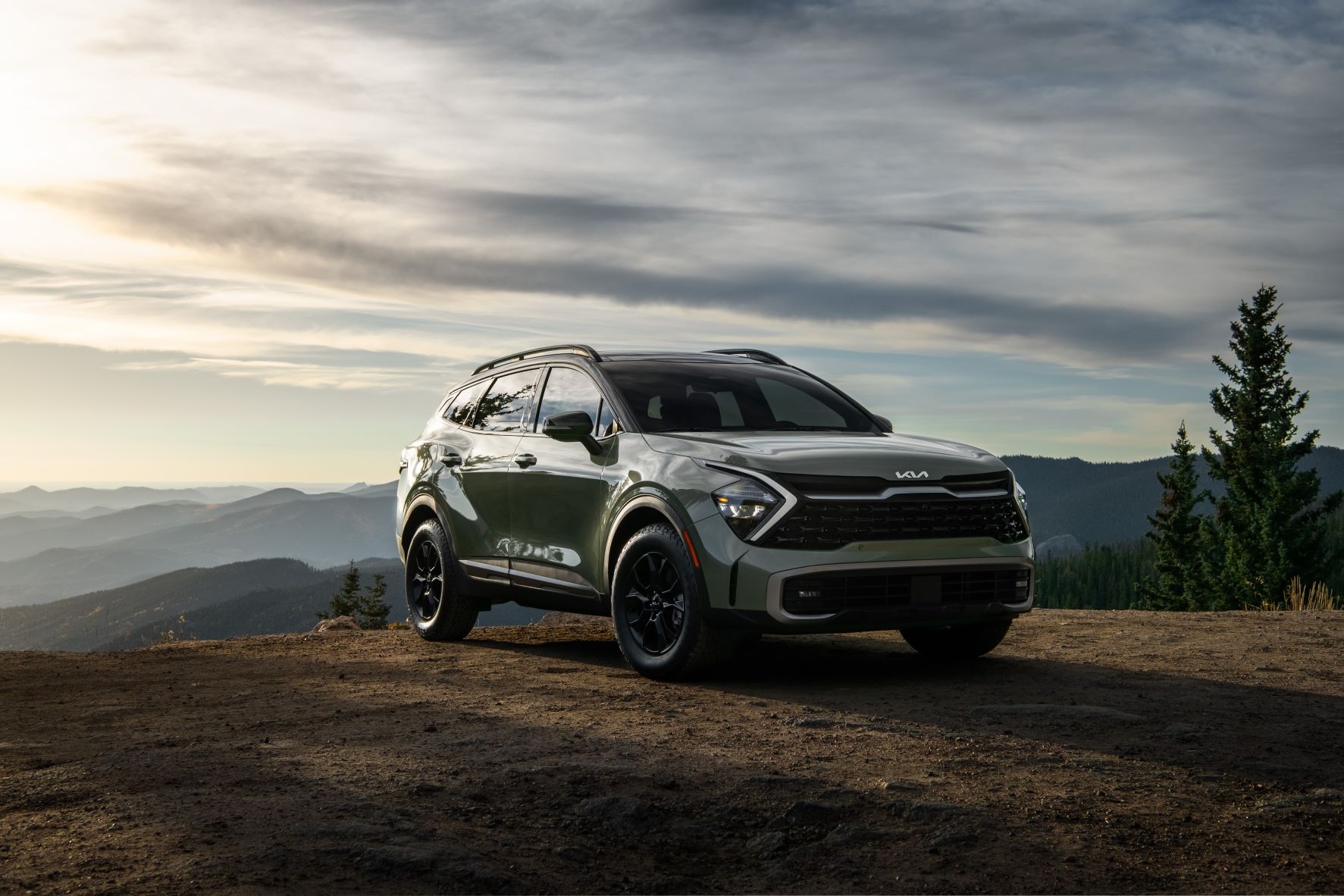 Groupe beaucage kiaSportage 2023 vert en forêt vue de face